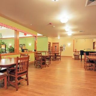 An empty restaurant dining area with wooden tables and chairs.