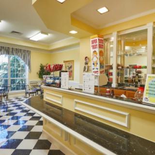 A cozy cafe interior with a checkered floor and a welcoming counter.