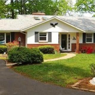 A suburban house with a well-maintained lawn and driveway.
