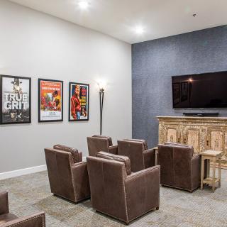A modern home theater setup with comfortable seating and artwork on the walls.