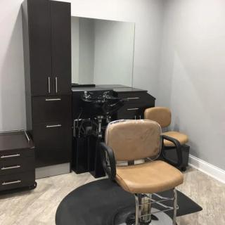 A well-organized hair salon station featuring a salon chair, mirror, and cabinet.