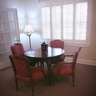 A cozy dining area with a round wooden table and four upholstered chairs.