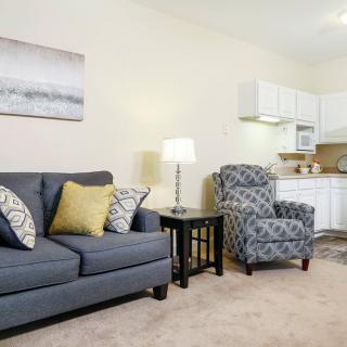 A cozy living room with a comfortable sofa, patterned armchair, and warm lighting.