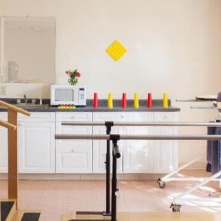 A rehabilitation room equipped with parallel bars and therapy tools.