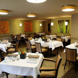 A stylish and modern dining area featuring neatly arranged tables and comfortable chairs.