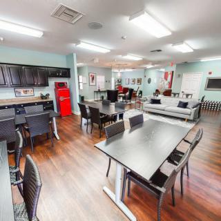 A modern kitchen and dining area with various tables, chairs, and appliances.