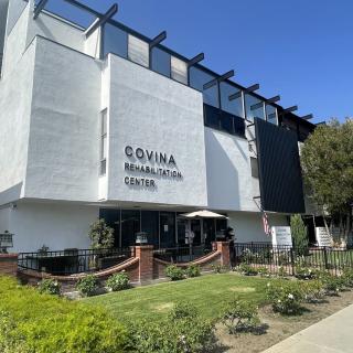 A modern school building with a landscaped garden area in front, captured during the daytime.