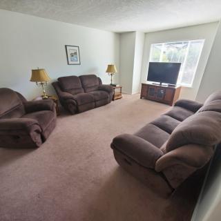 A cozy living room with brown sofas, a TV, and lamps.