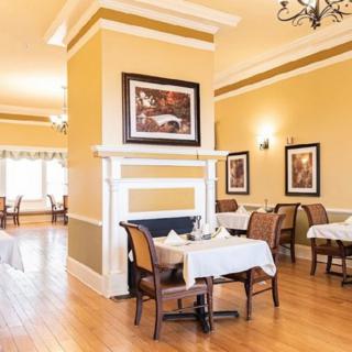 A warmly lit restaurant dining area with neatly arranged tables and elegant decor.