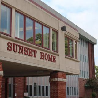 Exterior view of the Sunset Home nursing facility with brick architecture.