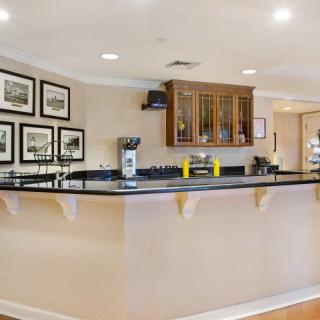 A stylish bar area with a polished counter, decorated with framed pictures and modern furnishings.
