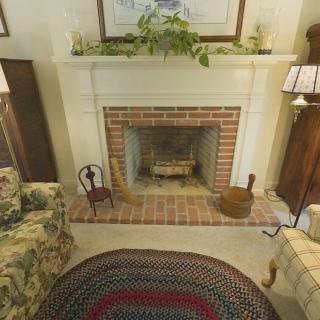 A cozy living room with a traditional brick fireplace and comfortable furnishings.