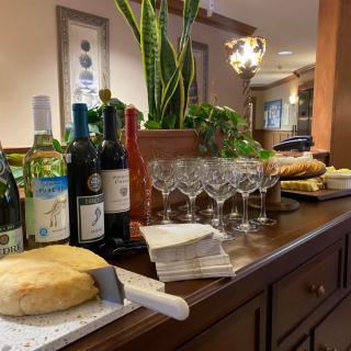 A dining setup featuring wine bottles, glasses, and a loaf of bread on a table in a restaurant.