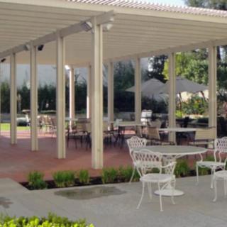 An outdoor patio area featuring a pergola with tables and chairs.