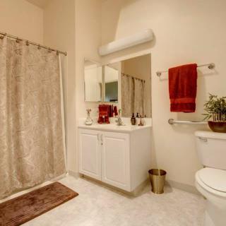 A modern bathroom with a large mirror, vanity sink, and decorative elements.