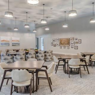 A spacious modern dining area with stylish tables, chairs, and decorative wall art.