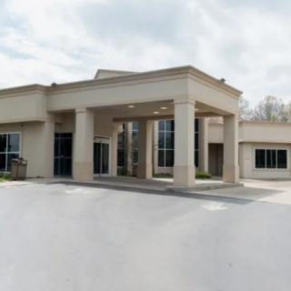 A modern building with a columned entrance and surrounding pavement.