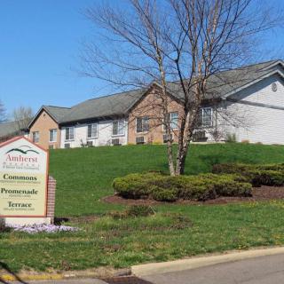 A community center building with a sign in front and well-maintained landscaping.