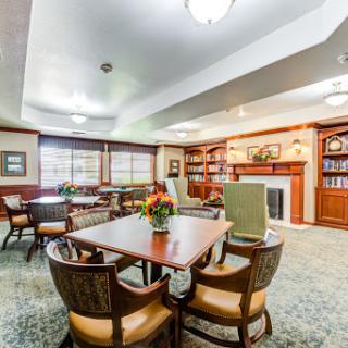 A cozy and inviting community lounge with comfortable seating and a fireplace, ideal for social gatherings or quiet reading.