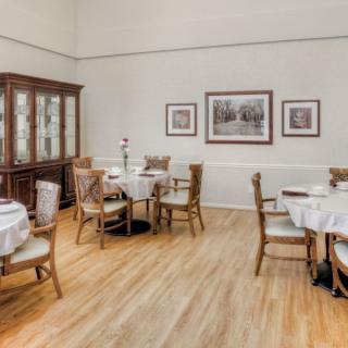 A cozy dining room with neatly arranged tables and chairs, featuring elegant decor.