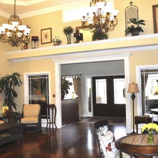 A cozy living room with elegant chandeliers, plush furniture, and decorative plants enhancing the warm ambiance.