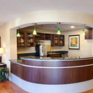 A modern reception desk with wooden accents and contemporary lighting in an office setting.