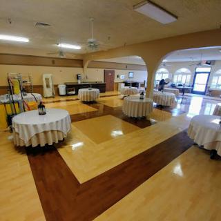 A spacious indoor event venue set up with round tables, ready for a gathering.