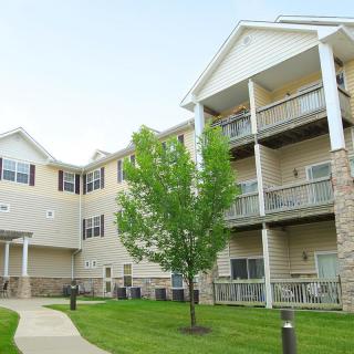 A view of a modern apartment building with balconies and a well-maintained lawn.