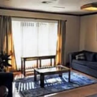 A cozy living room with a sofa, coffee table, and large window.