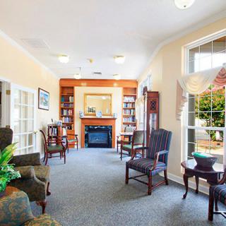 A cozy living room with traditional furniture, a fireplace, and bookshelves.
