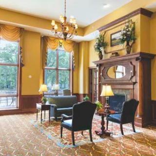 An elegant and cozy lobby with a fireplace, featuring comfortable seating and natural light.
