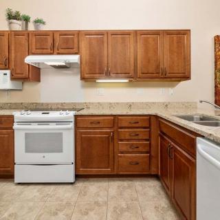 A modern kitchen with wooden cabinets, a white stove, and a dishwasher.