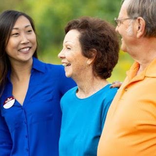 A joyful moment of conversation among friends in a sunny outdoor setting.