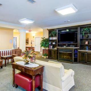 A cozy living room area with a large TV, comfortable seating, and elegant furnishings.