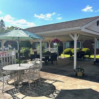 A spacious outdoor seating area featuring tables and canopies, perfect for enjoying a sunny day.
