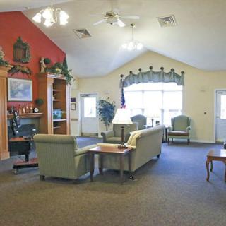 A cozy and spacious living room with traditional decor, featuring sofas and a carpeted floor.