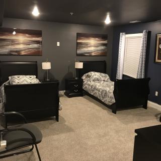 A cozy bedroom with two twin beds and stylish decor.