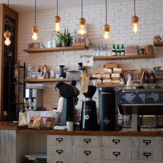 A cozy coffee shop with a barista preparing drinks behind the counter.