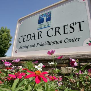 Cedar Crest Nursing and Rehabilitation Center sign surrounded by flowers.