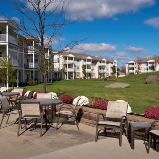 A scenic view of a residential area with outdoor patio seating and green lawns.