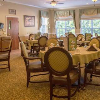 A well-decorated dining room with elegant furniture and large windows.