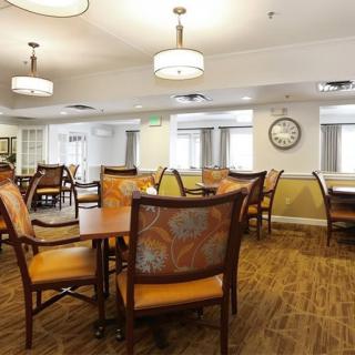 A well-lit dining area with neatly arranged tables and chairs.