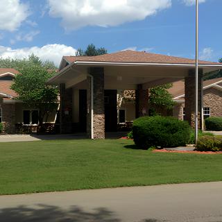 A residential building with a well-maintained lawn and clear blue sky.