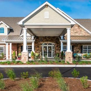 A well-maintained building entrance featuring columns and landscaped surroundings.
