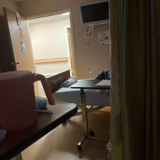 A view of a hospital room containing a bed and medical equipment.