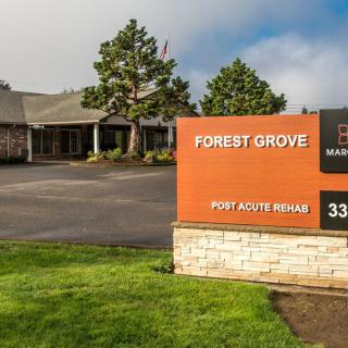 Entrance to a commercial building with a prominent Forest Grove sign and well-maintained landscaping.