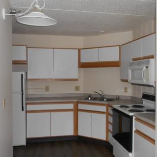 A modern kitchen featuring white cabinets and essential appliances.