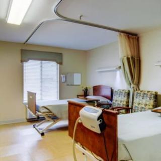 A view of a hospital room with a patient bed and medical equipment.