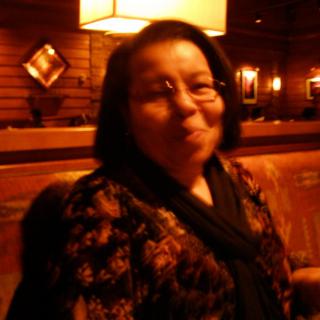 A woman sitting in a dimly lit restaurant.