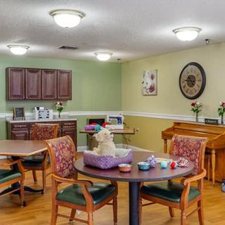 A cozy dining area with tables and chairs, featuring decorative elements and warm lighting.